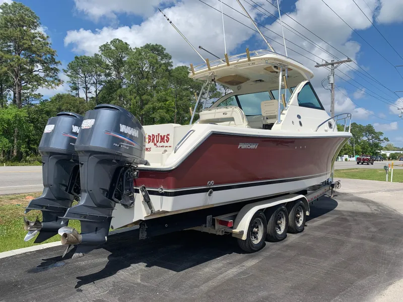 Slide: The Image of 2008 Pursuit 315 OS boat with dual Yamaha engines on a trailer. - 2