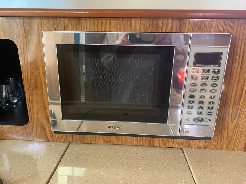 Slide: The Image of Built-in microwave in 2008 Pursuit 315 OS boat kitchen, wood paneling, digital controls. - 20