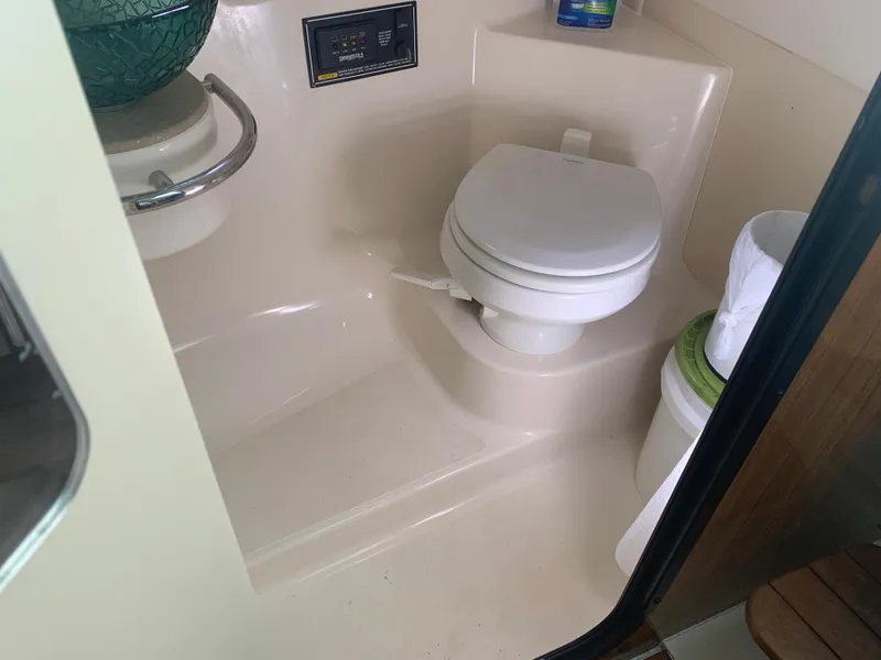 Slide: The Image of 2008 Pursuit 315 OS boat bathroom with toilet and storage area. - 24