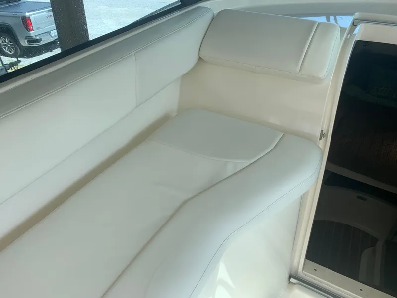 Slide: The Image of 2008 Pursuit 315 OS boat interior with white cushioned seating. - 34