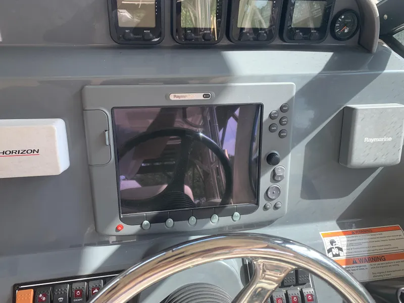 Slide: The Image of Dashboard of a 2008 Pursuit 315 OS boat with navigation equipment and steering wheel. - 41