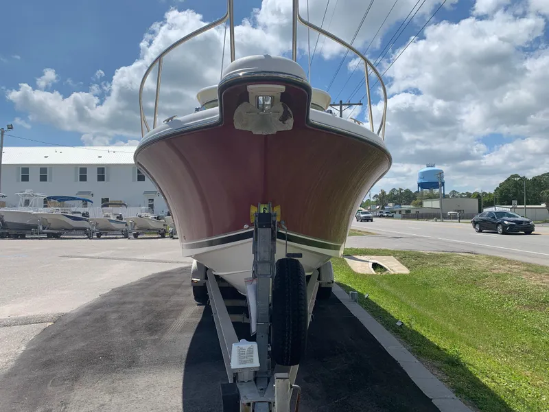 Slide: The Image of 2008 Pursuit 315 OS boat on trailer, parked outdoors under a partly cloudy sky. - 5
