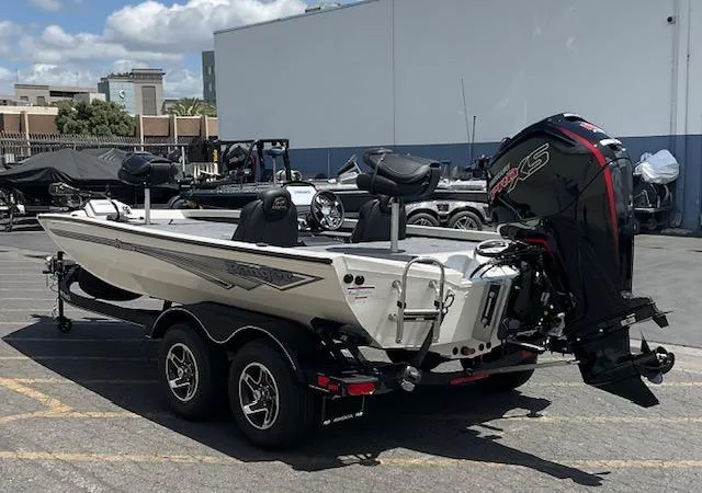 Slide: The Image of 2025 Ranger RT188P boat with dual axle trailer, parked outdoors under a cloudy sky. - 3