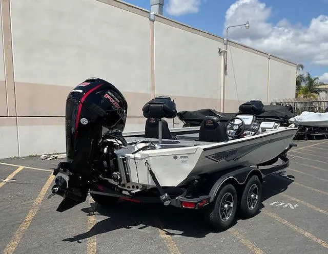 Slide: The Image of 2025 Ranger RT188P boat with powerful outboard motor, parked in a lot under a clear sky. - 7