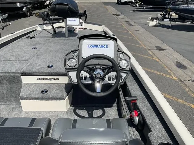 Slide: The Image of 2025 Ranger RT188P boat interior with Lowrance electronics and steering wheel, docked outdoors. - 9