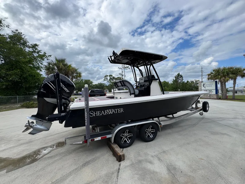 Slide: The Image of 2018 ShearWater 260 Carolina Flare boat on trailer, parked outdoors under cloudy sky. - 10