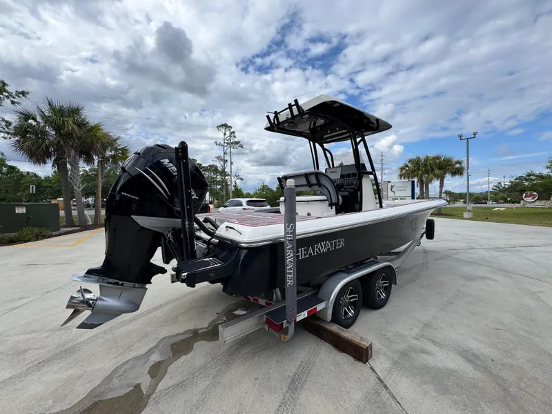 Slide: The Image of 2018 ShearWater 260 Carolina Flare boat on trailer, parked outdoors under cloudy sky. - 11