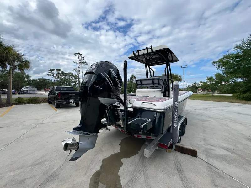 Slide: The Image of 2018 ShearWater 260 Carolina Flare boat on trailer, parked outdoors under cloudy sky. - 12