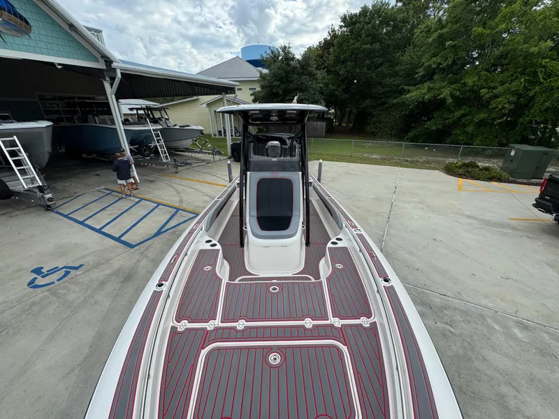 Slide: The Image of 2018 ShearWater 260 Carolina Flare boat with sleek deck design in a marina setting. - 17