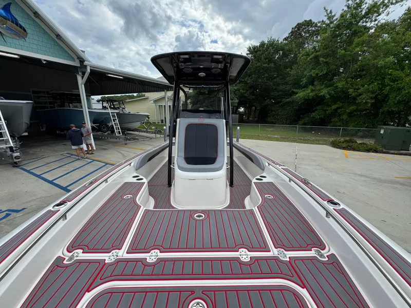 Slide: The Image of 2018 ShearWater 260 Carolina Flare boat with red and gray deck, docked outdoors. - 18