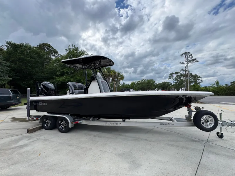 Slide: The Image of 2018 ShearWater 260 Carolina Flare boat on trailer, parked outdoors under cloudy sky. - 8