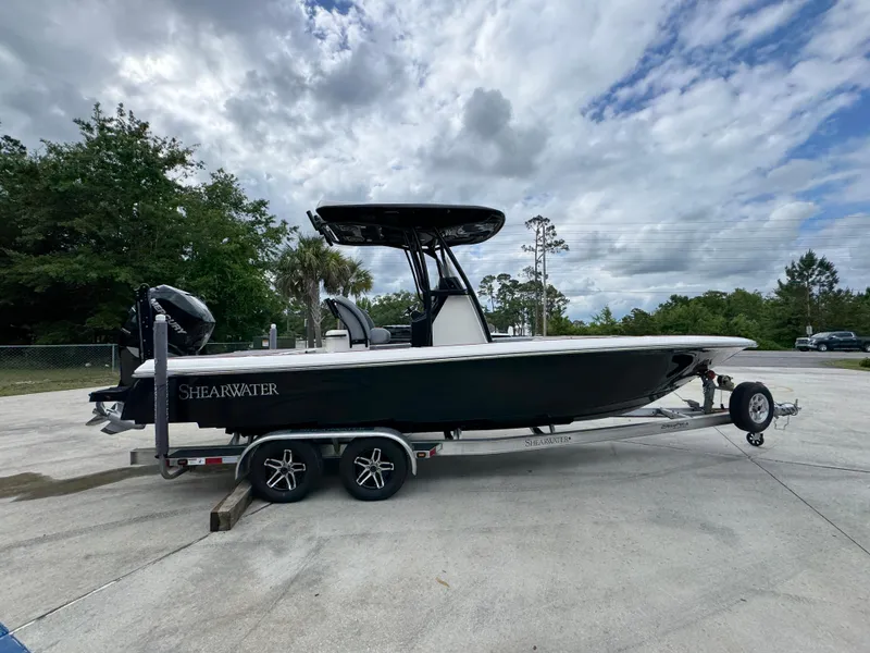 Slide: The Image of 2018 ShearWater 260 Carolina Flare boat on trailer, parked outdoors under cloudy sky. - 9