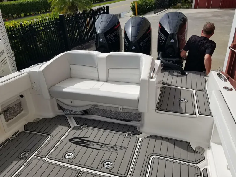 Slide: The Image of 2020 Nor-Tech Center Console boat with triple outboard engines and cushioned seating. - 5