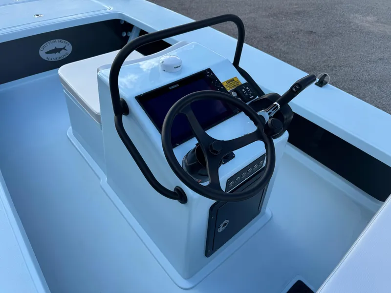 Slide: The Image of 2024 Chittum Skiffs 21 Mangrove boat console with steering wheel and navigation controls. - 13