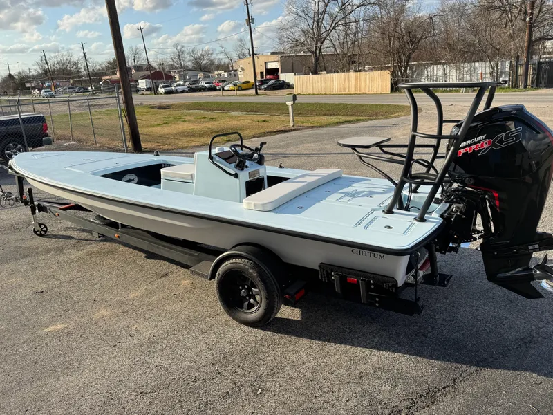 Slide: The Image of 2024 Chittum Skiffs 21 Mangrove boat on trailer, parked outdoors. - 8