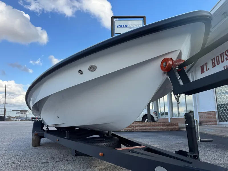 Slide: The Image of 2024 Chittum Skiffs 21 Mangrove boat on trailer, parked outdoors under a blue sky. - 9