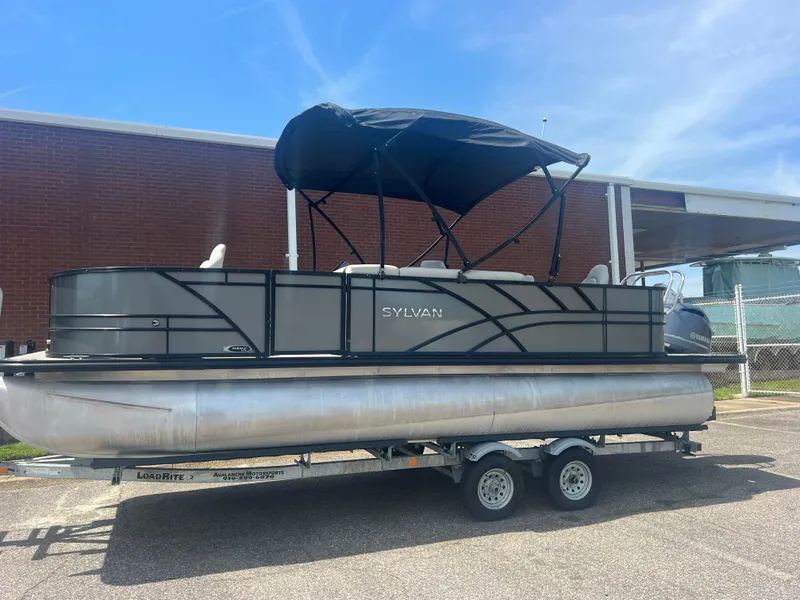 Slide: The Image of 2021 Sylvan Mirage Fish 8522 Party Fish pontoon boat on trailer, outdoor setting. - 2