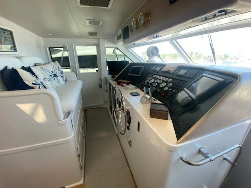 Slide: The Image of 1989 Hatteras Custom Cockpit interior with helm, gauges, and seating area. - 12