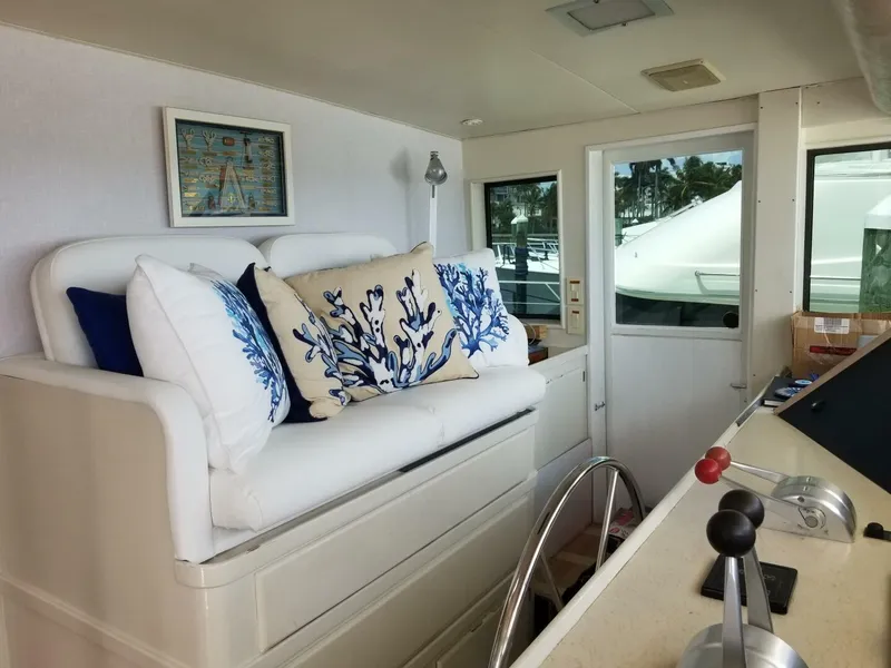Slide: The Image of 1989 Hatteras Custom Cockpit interior with nautical-themed cushions and helm controls. - 13