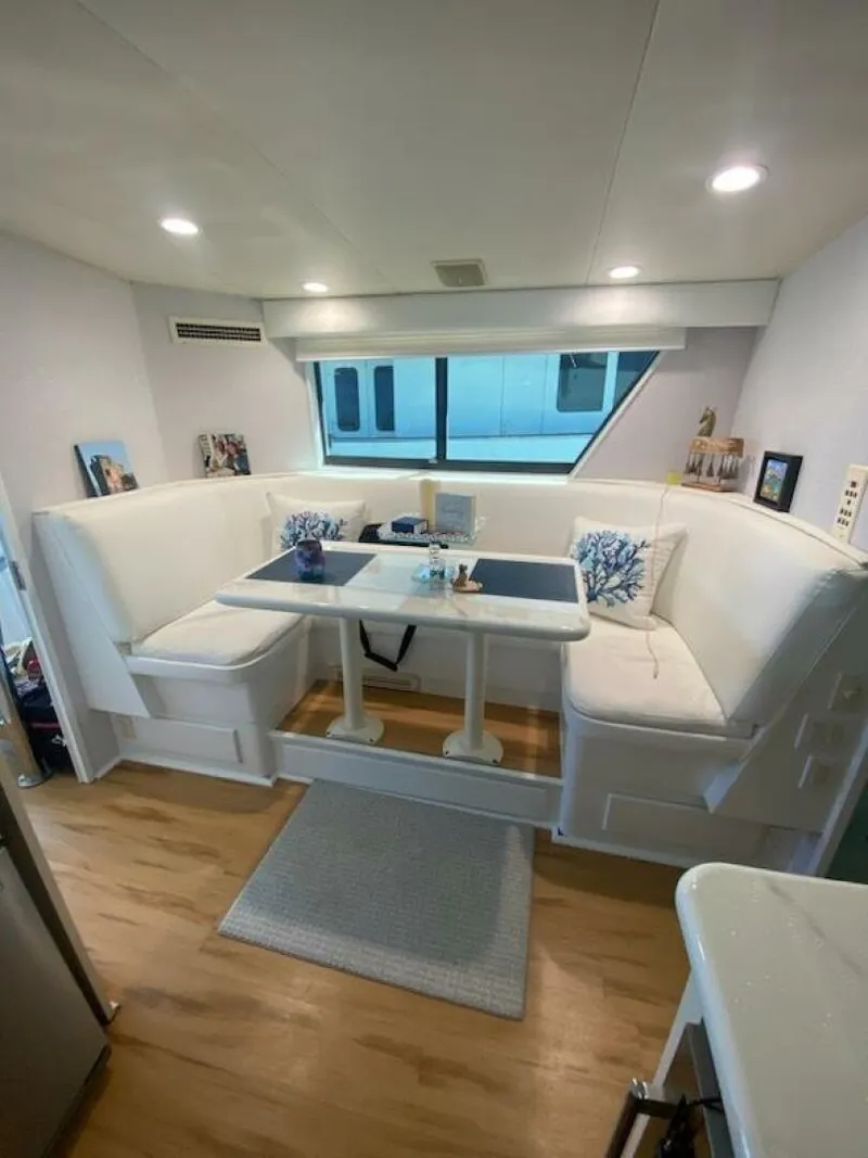 Slide: The Image of 1989 Hatteras Custom Cockpit interior with white seating and dining area. - 20