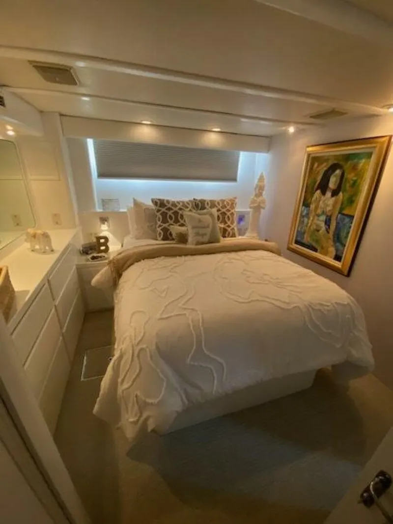 Slide: The Image of Luxurious bedroom in 1989 Hatteras Custom Cockpit yacht with elegant decor and artwork. - 24