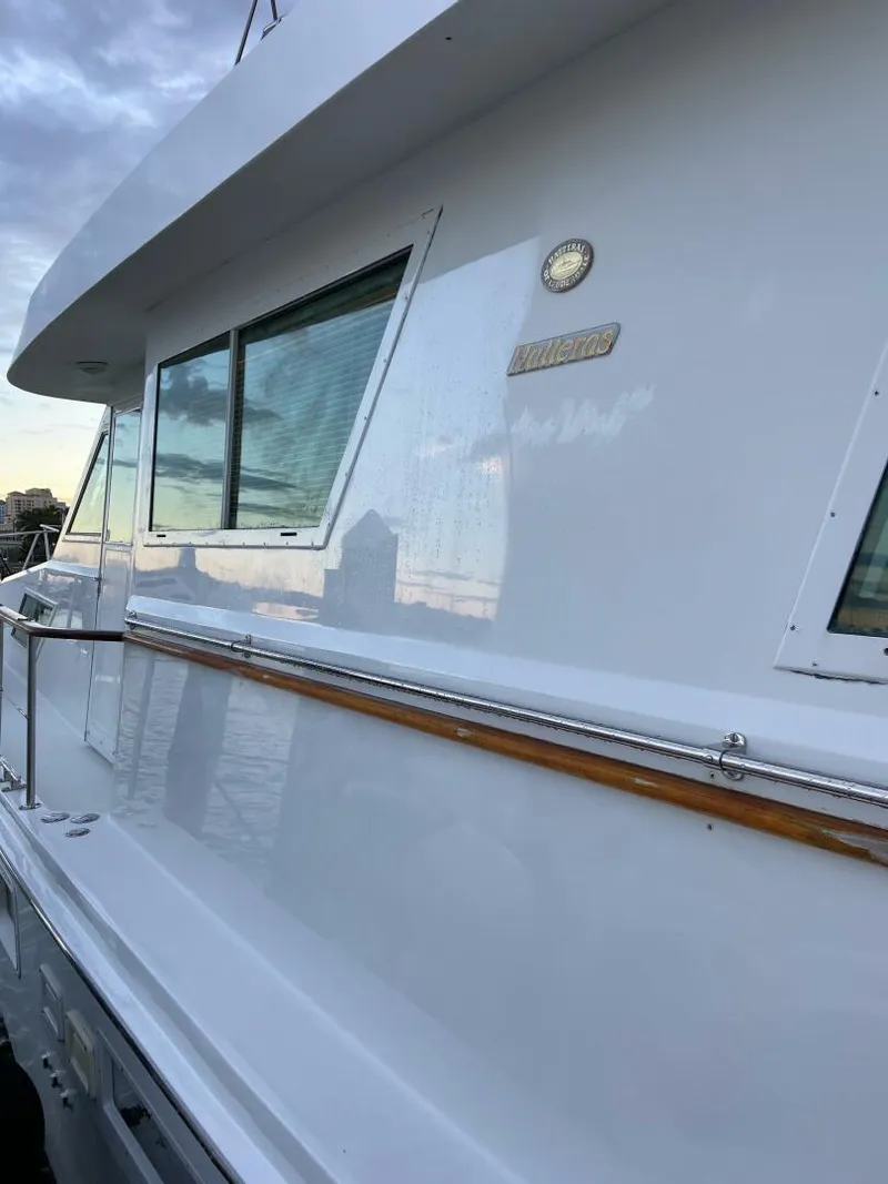 Slide: The Image of 1989 Hatteras Custom Cockpit yacht with sleek white exterior and wooden trim. - 3