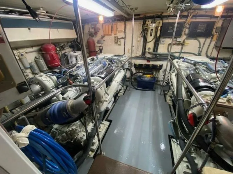 Slide: The Image of Engine room of 1989 Hatteras Custom Cockpit yacht, featuring dual engines and organized equipment. - 34