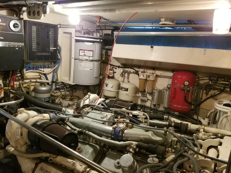 Slide: The Image of Engine room of 1989 Hatteras Custom Cockpit boat, showcasing complex machinery and wiring. - 35