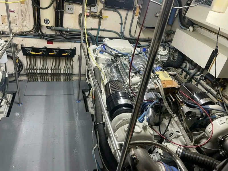 Slide: The Image of Engine room of 1989 Hatteras Custom Cockpit yacht, showcasing mechanical components and wiring. - 36