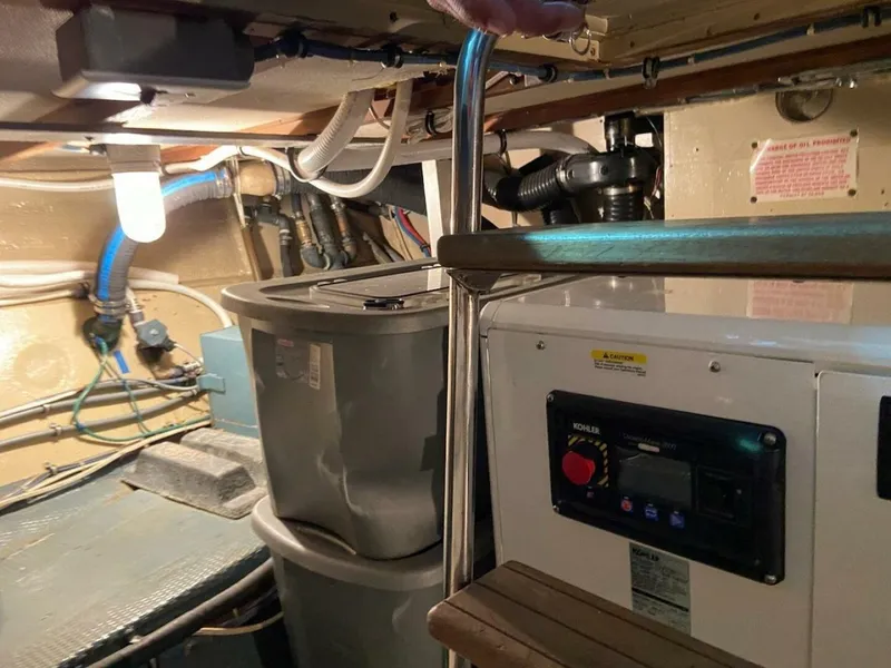 Slide: The Image of Engine room of 1989 Hatteras Custom Cockpit boat with equipment and storage containers. - 38