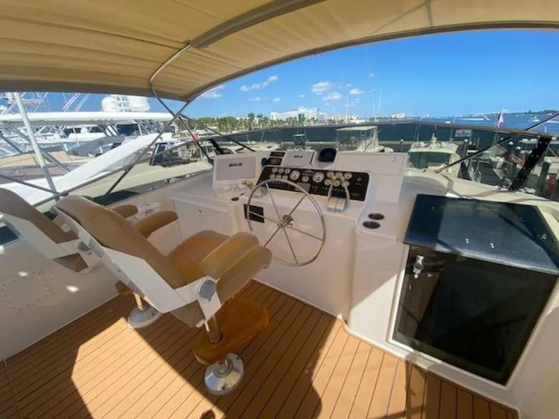 Slide: The Image of 1989 Hatteras Custom Cockpit with dual helm seats, steering wheel, and marina view. - 4