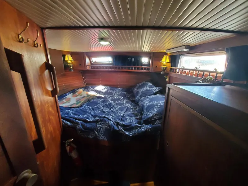 Slide: The Image of Cozy cabin interior of 1982 Nauticat 38 sailboat with wooden furnishings and double bed. - 4