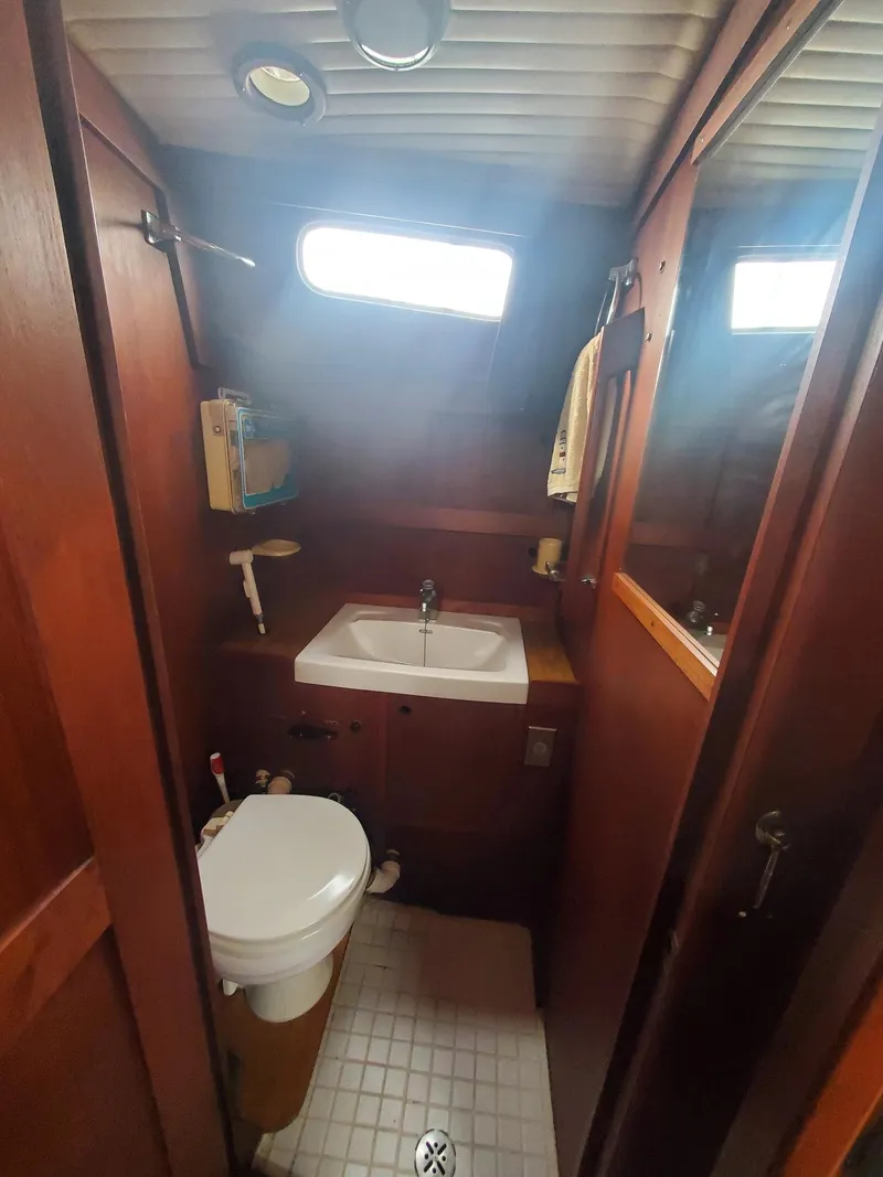 Slide: The Image of 1982 Nauticat 38 yacht bathroom with wooden interior, sink, and toilet. - 6
