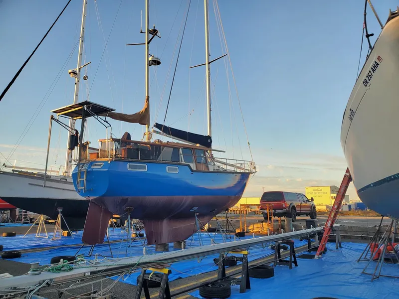 Slide: The Image of 1982 Nauticat 38 sailboat on dry dock, surrounded by other boats and equipment. - 7