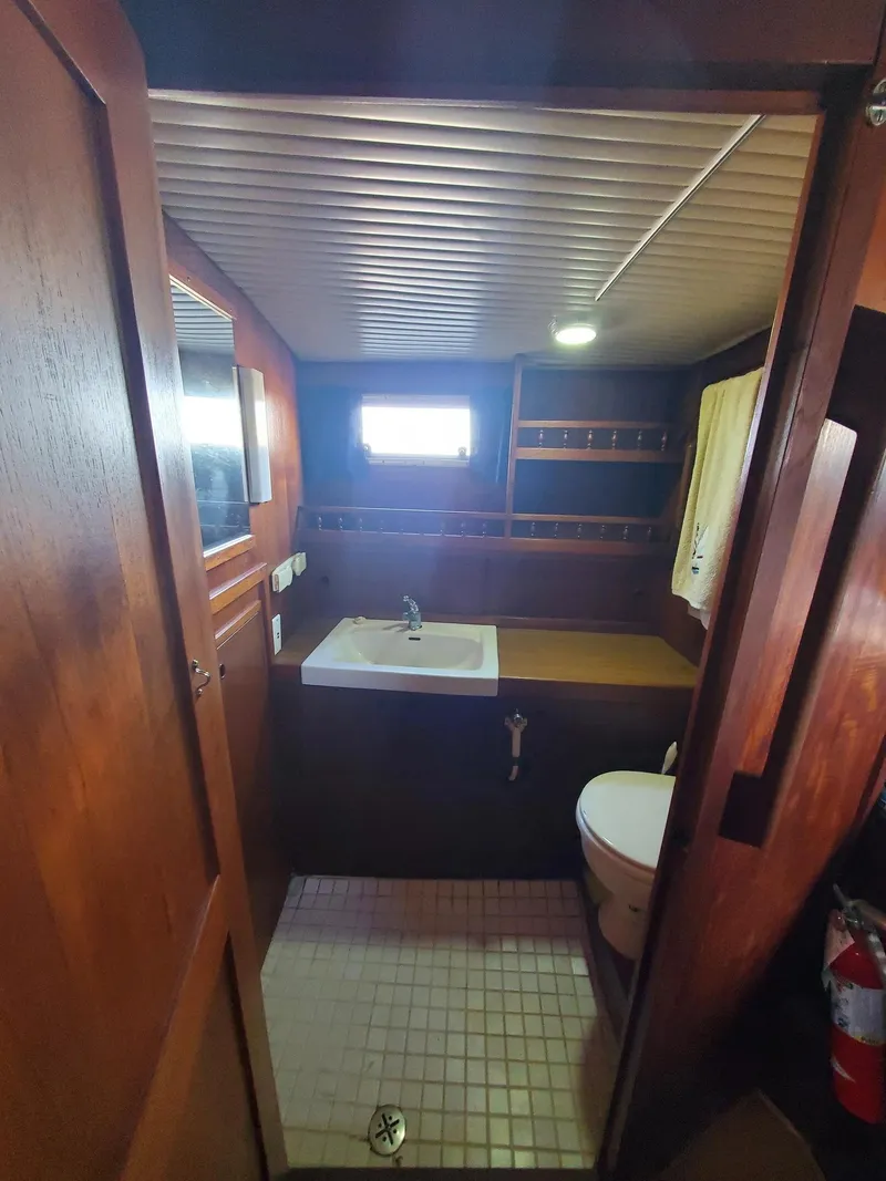 Slide: The Image of 1982 Nauticat 38 yacht bathroom with wooden interior, sink, and toilet. - 8
