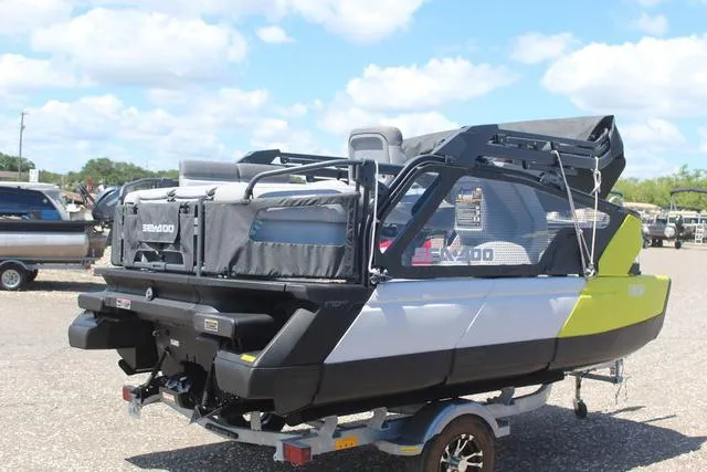 Slide: The Image of 2024 Sea-Doo Switch® Cruise 18 - 170 hp pontoon boat on trailer, parked outdoors. - 4