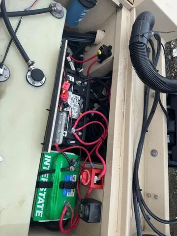 Slide: The Image of 2022 G3 BAY 22 DELUXE boat battery compartment with wiring and Interstate battery. - 16