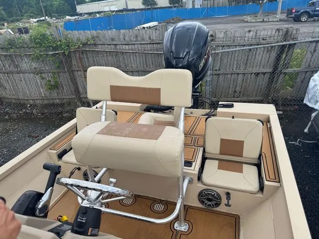 Slide: The Image of 2022 G3 BAY 22 DELUXE boat interior with seating and motor, parked outdoors. - 8