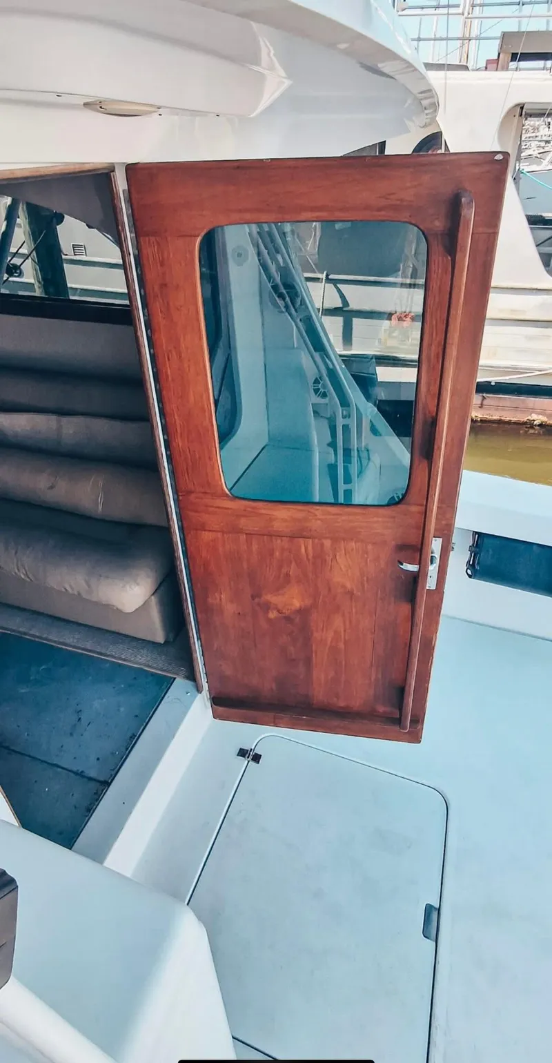 Slide: The Image of 1993 Luhrs 350 Tournament boat with open wooden cabin door and visible interior stairs. - 12