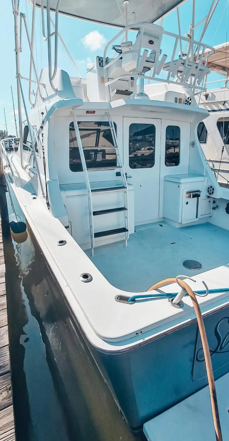 Slide: The Image of 1993 Luhrs 350 Tournament boat docked, featuring spacious deck and fishing equipment. - 3