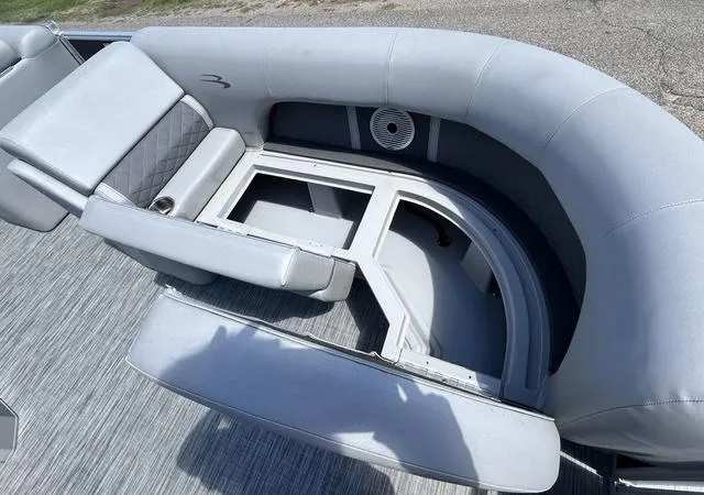 Slide: The Image of 2020 Bennington 22 SX boat interior with open storage compartments and cushioned seating. - 12