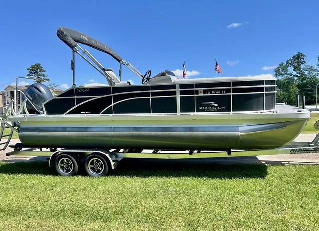 Slide: The Image of 2020 Bennington 22 SX pontoon boat on trailer, parked on grass under clear blue sky. - 3