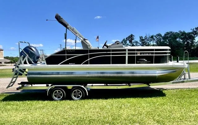 Slide: The Image of 2020 Bennington 22 SX pontoon boat on trailer, parked on grass under clear blue sky. - 4