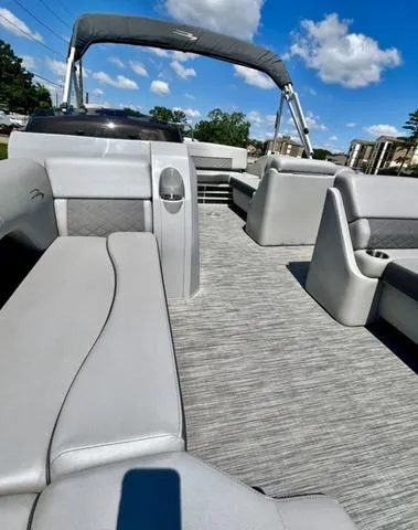 Slide: The Image of 2020 Bennington 22 SX pontoon boat with spacious seating and modern design under a clear blue sky. - 8