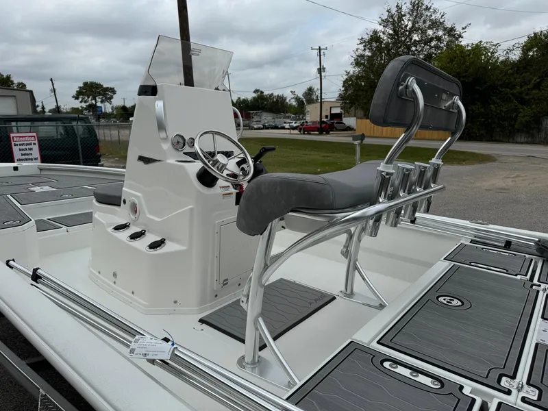 Slide: The Image of 2025 Avid 21 Mag boat with sleek console and seating, parked outdoors. - 7