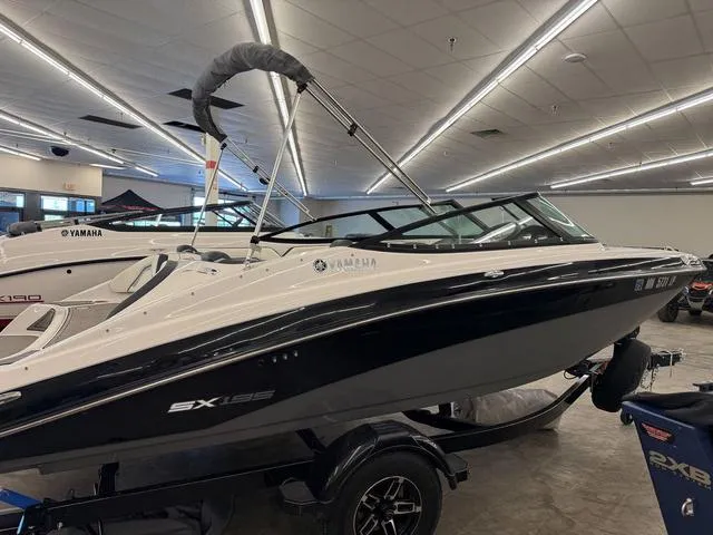 Slide: The Image of 2017 Yamaha Boats SX195 in showroom, sleek design, black and white color scheme. - 2