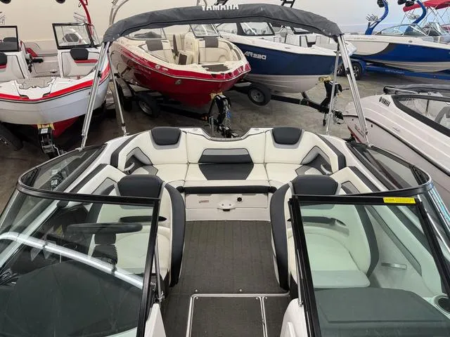 Slide: The Image of 2017 Yamaha Boats SX195 interior with sleek seating, surrounded by various boats in showroom. - 22