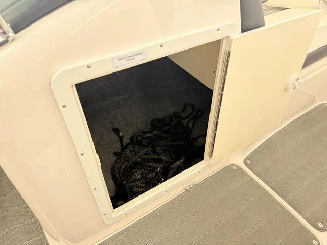 Slide: The Image of 2017 Yamaha SX195 boat storage compartment with coiled rope inside. - 13