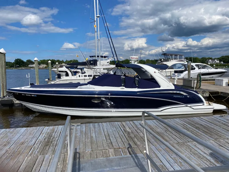 Slide: The Image of 2014 Formula 350 CBR boat docked at marina under blue sky. - 0