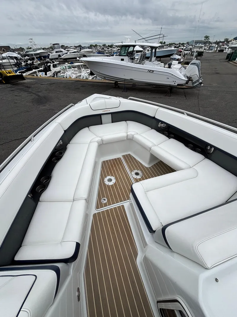 Slide: The Image of 2014 Formula 350 CBR boat with spacious white seating and wood-style flooring at a marina. - 17